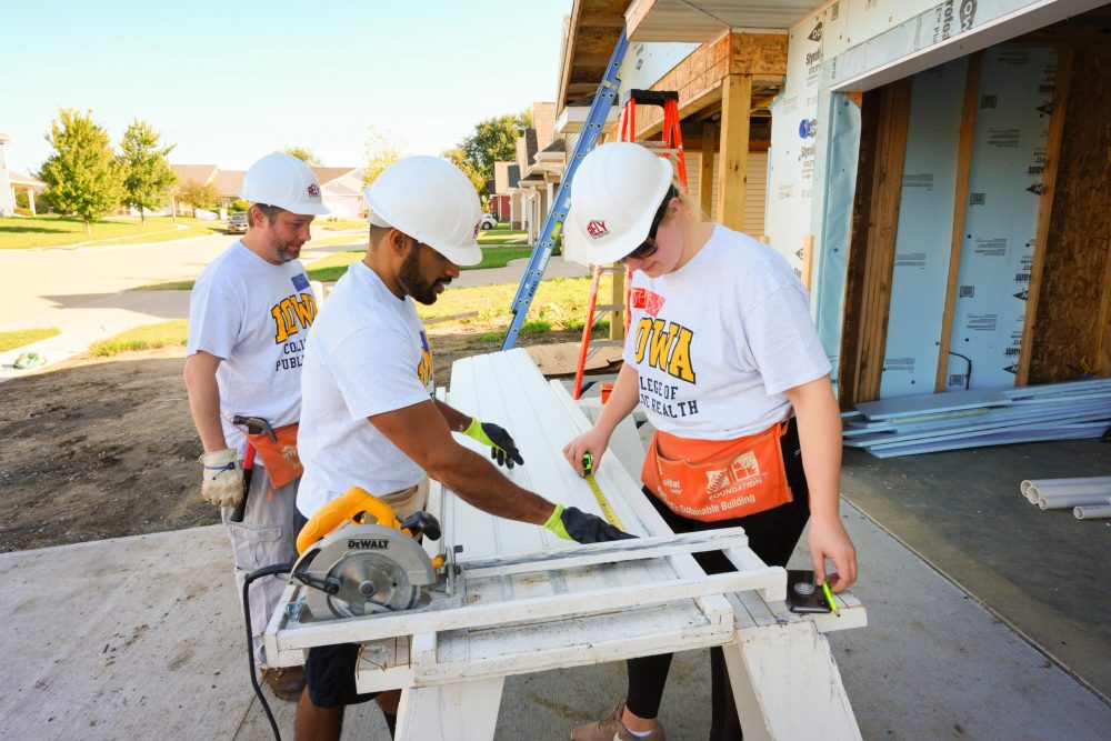 Students are working with Habitat for Humanity by measuring and cutting material for a new house.