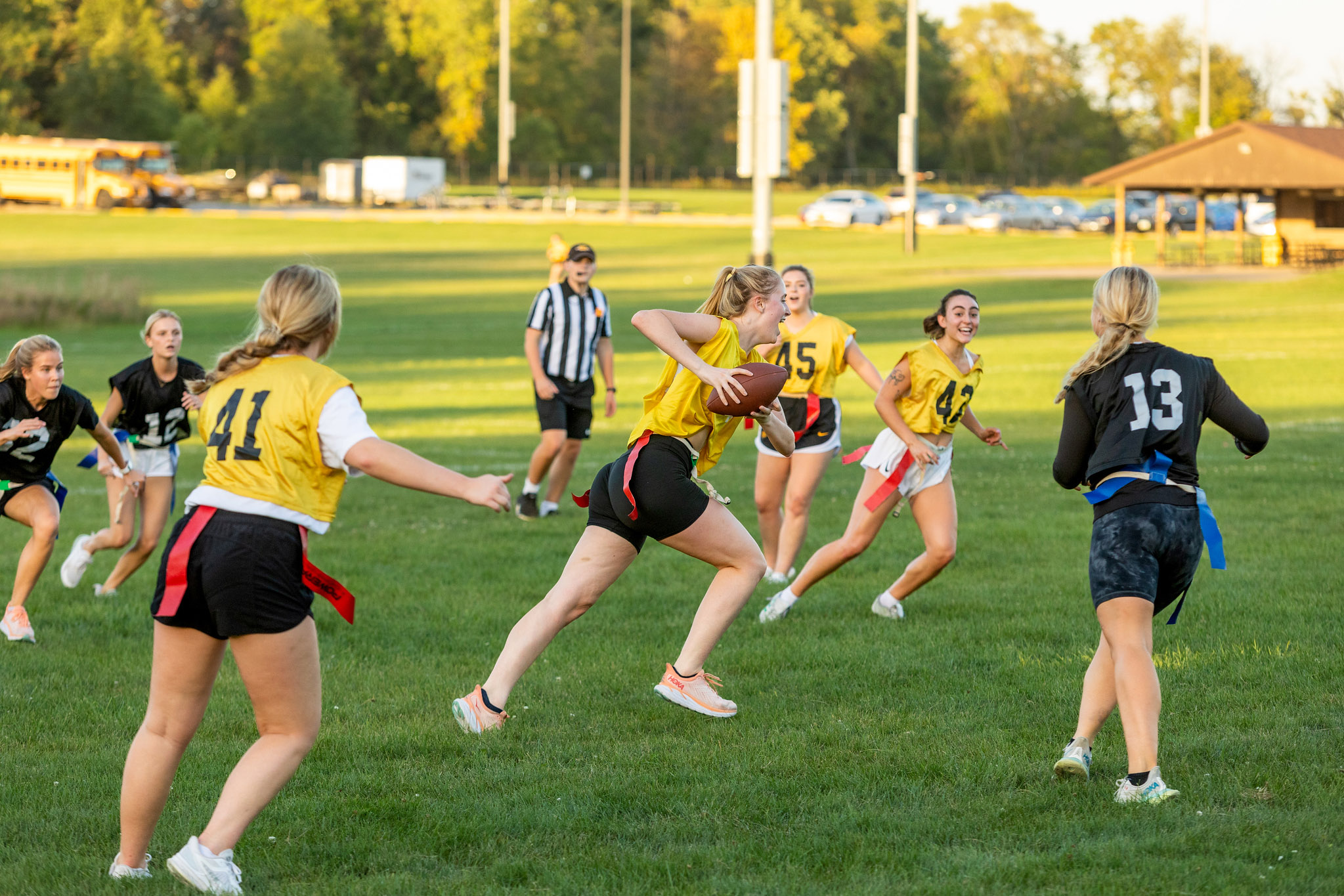 Students playing flag football outside on the grass