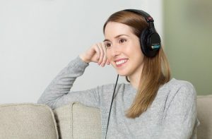 A woman with headphones on, listening to music