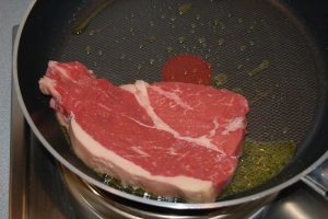 A raw steak in a skillet