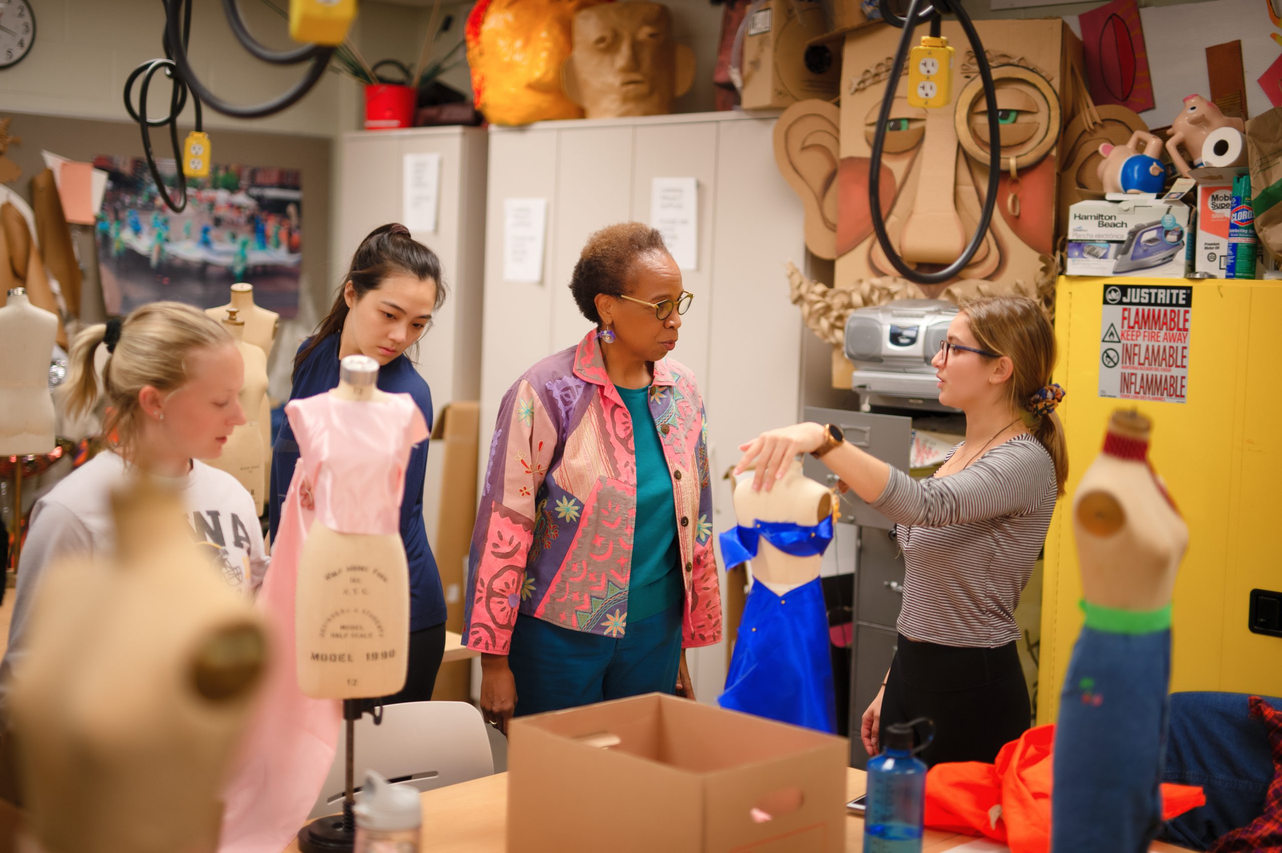 Associate Professor Loyce Arthur interacting with students working on costume designs in the Costume Studio in the Theatre Building.