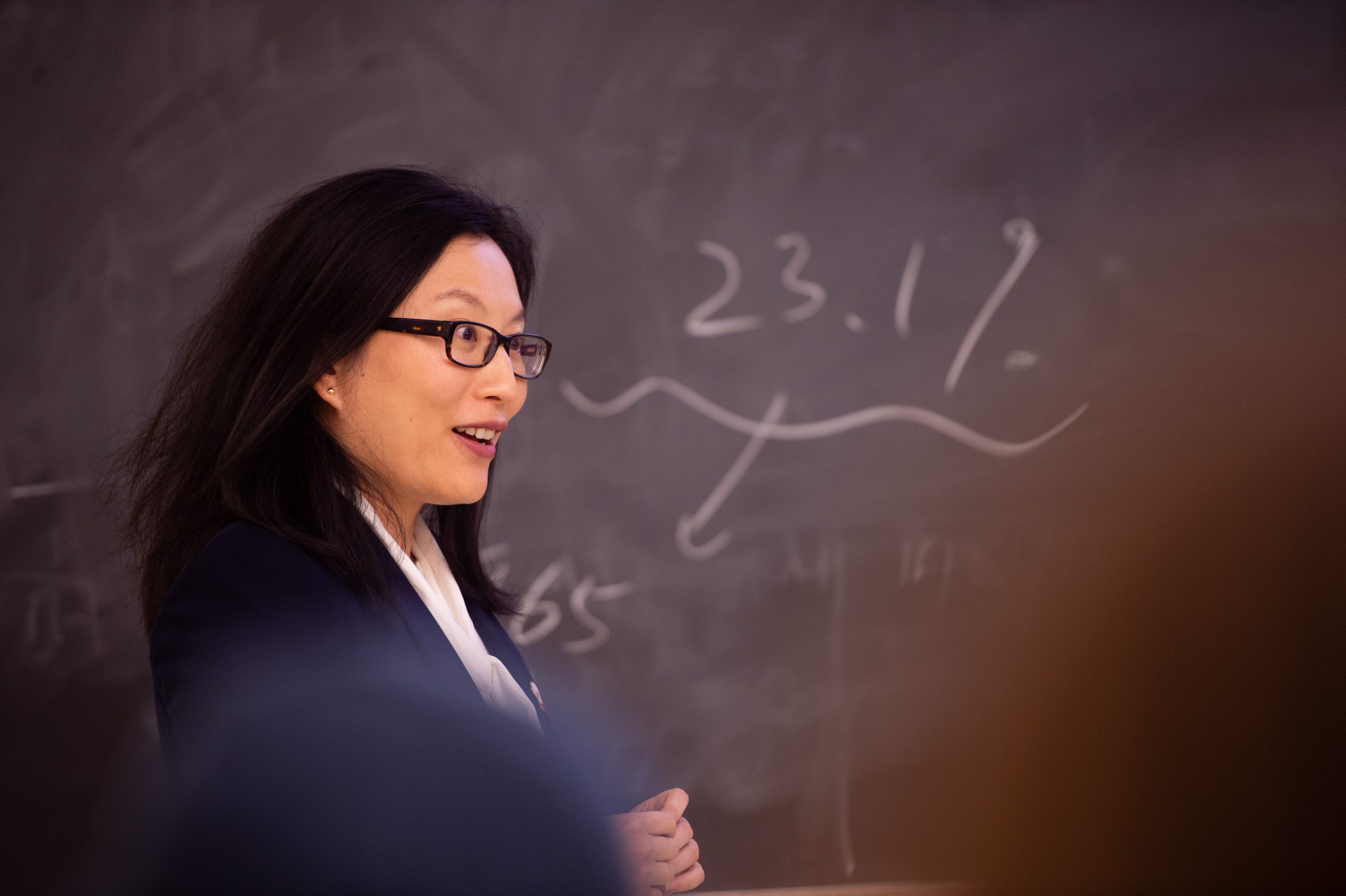 Instructor Jielu Yao standing in front of a blackboard in the Hawkeye Poll class.