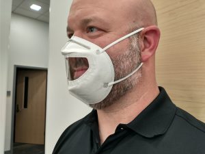 KN95 Mask with clear mouth insert worn on a white man.