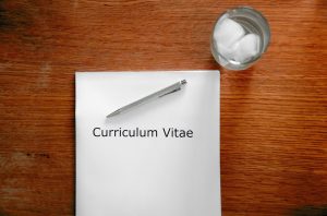 The words Curriculum Vitae appear in a piece of paper