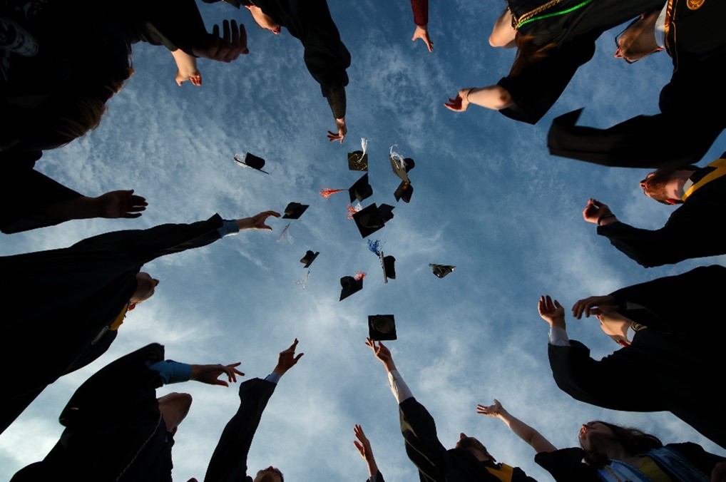 picture of students throwing graduation caps in the air