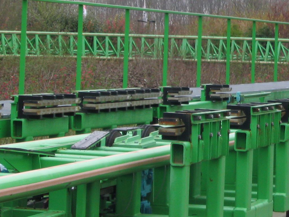 Photograph of a roller coaster track with rows of magnets protruding horizontally that are used for magnetic braking in roller coasters.