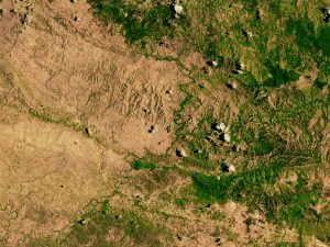 A river marks the border between a deforested and a green area