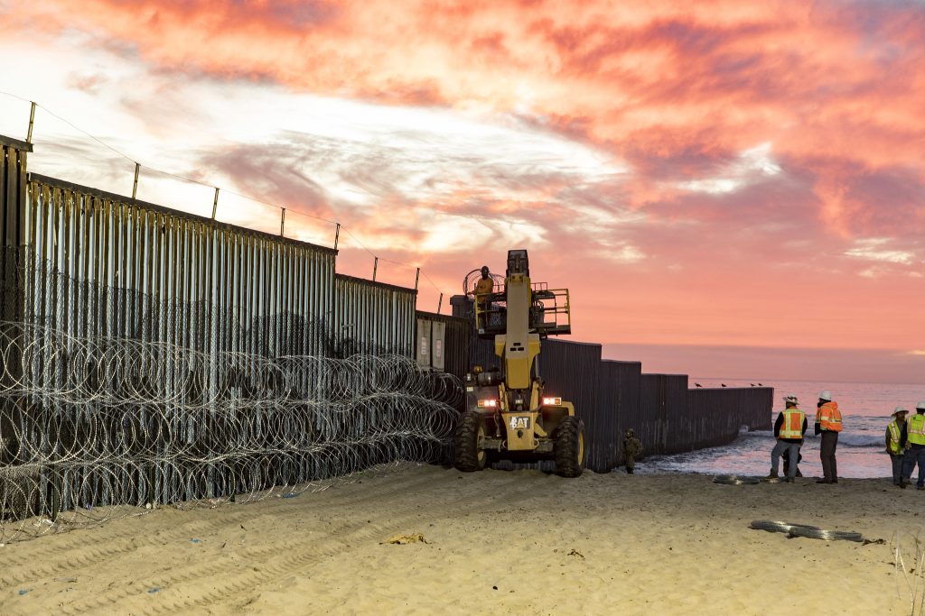 U.S. Border Patrol Agents at Border Field State Park in Imperial Beach watch over personnel that are reinforcing the border fence with concertina wire. Border Patrol remains vigilant in ensuring the safety of the American public and securing our borders.