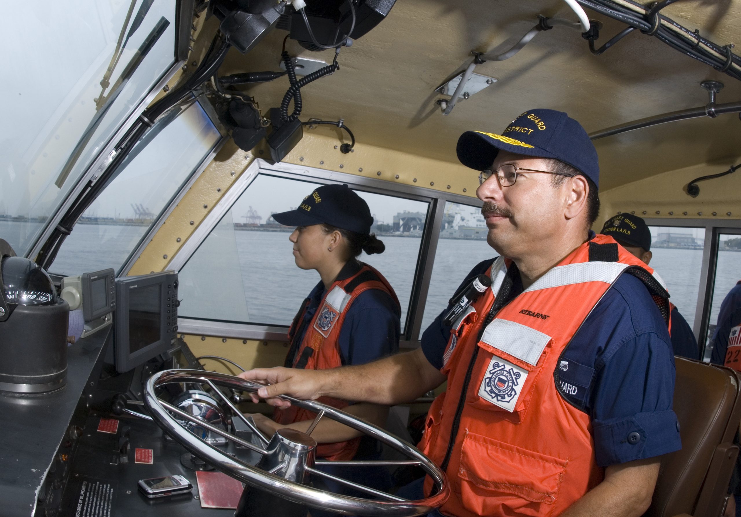 Coast Guard Officer of Hispanic descendant maneuvering a boat