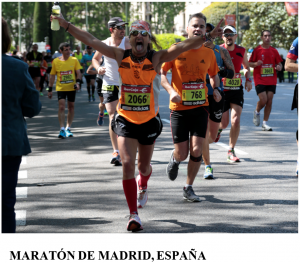 A runner raises his arms while participating at the Madrid marathon.