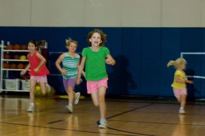 Children run around school gym